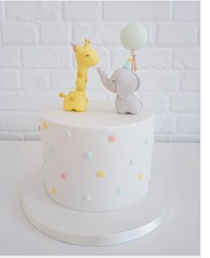 a white cake with an elephant and giraffe on top