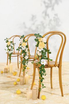 a row of chairs with flowers on them and candles in the middle, along with lemons