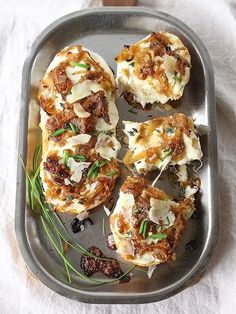 four appetizers are sitting on a metal tray