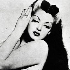 black and white photograph of a woman with long hair holding her hand to her head