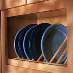 a wooden shelf filled with blue and white plates