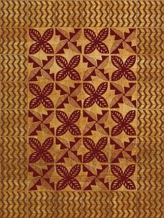 a red and gold quilt with leaves on it's sides, in the center