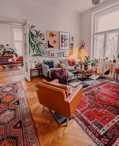 a living room filled with lots of furniture and rugs on top of hard wood flooring