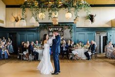 a bride and groom sharing their first dance in front of an audience at a wedding reception