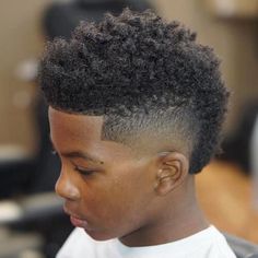 a young man with an afro haircut in a barbershop looking to his left