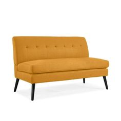 an orange couch sitting on top of a white floor next to a wooden leg chair