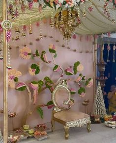 a room decorated in pink and gold with flowers on the wall, chandelier and mirror