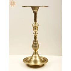 a brass candle holder on a white background