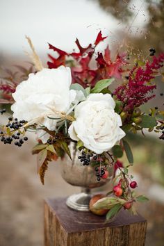 a vase filled with flowers sitting on top of a wooden block