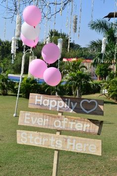 a wooden sign with balloons attached to it