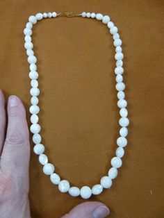 (Internal #V461-30)  You are bidding on a beautiful, handmade mother of pearl white beaded necklace with 8x10mm oval and 10mm round beads, 20” long with gold alloy safety clasp closure.  LOVELY.This is the exact necklace you will receive.WE SHIP WORLDWIDE! Other accepted payment: Credit card (Mastercard/Visa/Discover) inquire for details. Adjustable Round Pearl Necklace With Gemstone Beads, Adjustable Pearl Necklace With Gemstone Beads, Pearl Necklace With Large Beads As Gift, Single Strand Mother Of Pearl Necklace With Round Beads, Large Beads Pearl Necklace As Gift, Pearl White Necklaces With Gemstone Beads, Vintage White Jewelry With Gemstone Beads, Vintage White Gemstone Beads Jewelry, Classic Beaded Jewelry With Oval Beads