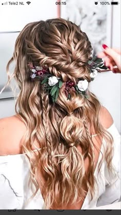 a woman with long hair and flowers in her hair is getting ready to go into the wedding