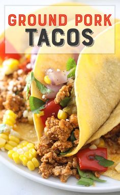 two tacos on a white plate with corn and tomatoes in the background text reads ground pork tacos