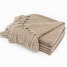 four tan towels folded on top of each other with fringes in the middle and bottom