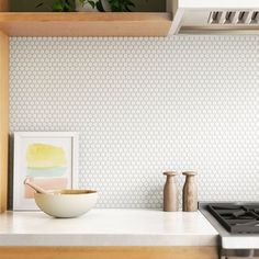 a kitchen with a bowl on the counter and a stove top in front of it