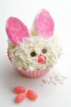 a cupcake with white frosting and pink bunny ears