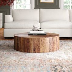 a living room with a white couch and wooden coffee table in it's center