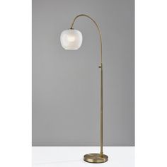 a brass floor lamp with a white glass ball on the top and a gold base