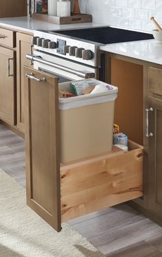 a kitchen with an open dishwasher in the middle and drawers on both sides