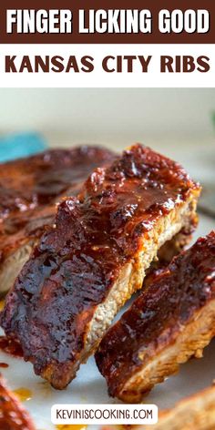 two pieces of ribs sitting on top of a white plate with ketchup sauce