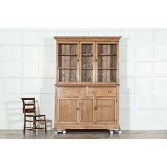 an old wooden china cabinet next to a chair