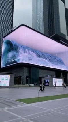 people are walking around in front of a building with an iceberg advertisement on it