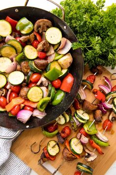 vegetables being cooked in a skillet on a cutting board