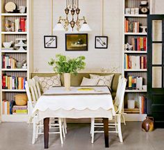 a dining room with bookshelves, table and chairs in front of the bookcases