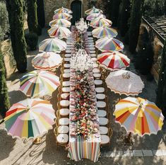 an overhead view of tables covered with umbrellas and plates on the table in front of them