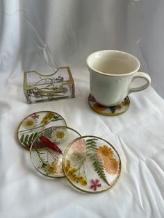 Floral infused round resin coaster with gold trim and matching coaster holder. This set includes 4 round coaster and a matching coaster holder. Each coaster and coaster holder has dried flowers embedded into the resin and then are lined in gold acrylic paint. This dainty set is perfect for any gardener, tea party, wedding party, or your own garden nook. Round shaped coasters made using food-safe epoxy resin. All my items are made with food-safe resin products. It is a functional piece of artwork Book Coasters, Resin Book, Girls Night Crafts, Garden Nook, Gold Acrylic Paint, Resin Products, Essential Oil Storage, Tea Party Wedding, Resin Coaster