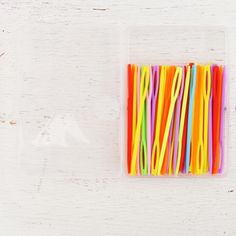 several different colored straws in a plastic container