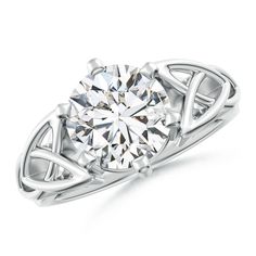 a white gold ring with a diamond in the center and an intricate design on top