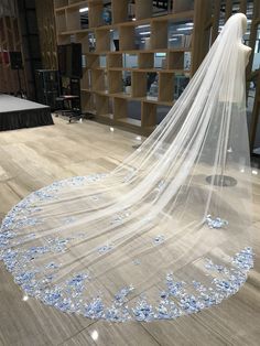 a wedding veil with blue flowers on the floor