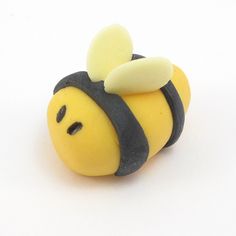 a yellow and black toy with a bee on it's back, sitting in front of a white background