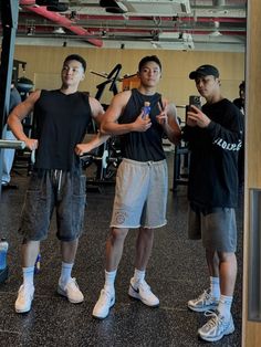 three young men standing next to each other in a gym