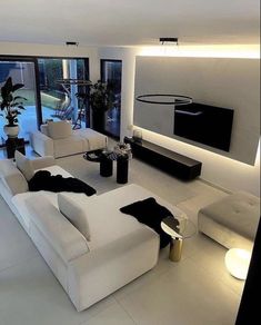 a modern living room with white furniture and large windows