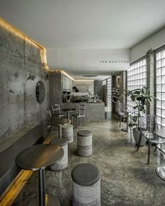 an empty restaurant with tables and stools in the center, along with large windows