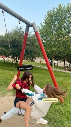 two people playing on a swing set in a park with the caption saying,