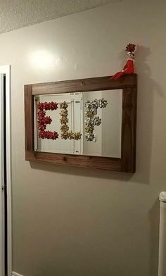 a bathroom mirror hanging on the wall next to a toilet in a room with white walls