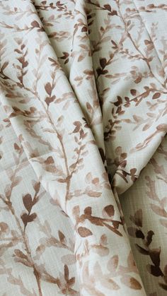 a close up view of a bed sheet with brown leaves on it and white sheets