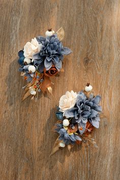 two blue and white flowers sitting on top of a wooden table next to each other