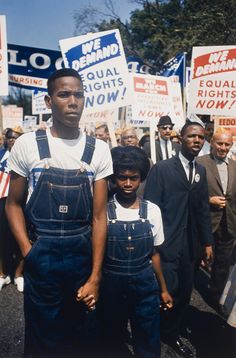 a group of people holding signs and standing next to each other