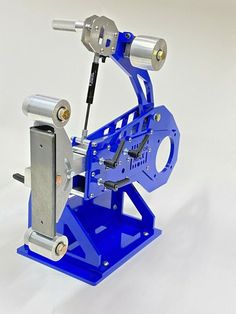 a machine that is sitting on top of a blue stand with two tools attached to it