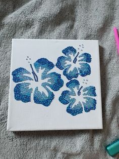 a blue and white flower is on a towel next to some crayon markers