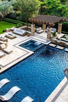 an outdoor swimming pool with lounge chairs around it