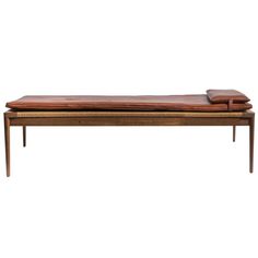 a wooden bench with leather cushions on it