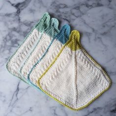 three crocheted dishcloths sitting on top of a marble counter