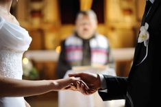 the bride and groom hold hands during their wedding ceremony