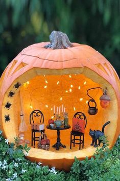 a pumpkin shaped like a table with chairs and a cat sitting on top of it