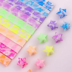 several different colored stars next to each other on a white surface with one rainbow star in the middle